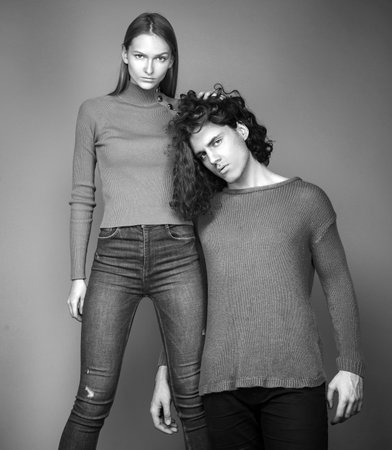 Sensual portrait of young couple. Couple of man with curly hair and blonde woman in hairdresser salon. Fashion couple on beige background in studio. Fashionable coupl.の写真素材