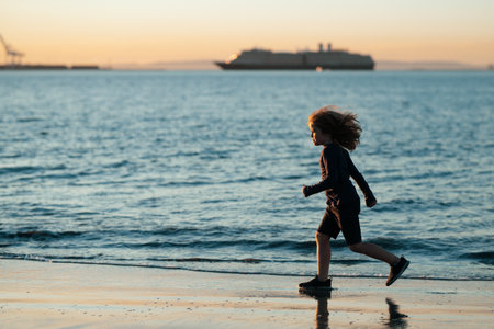 Kid running on beach. Happy child run in sea on summer vacation. Summer vacation with child.の写真素材