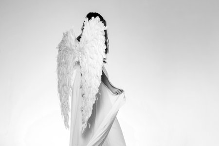 Angel girl. Long white wings. Wonderful blonde angel girl with white wings.の写真素材