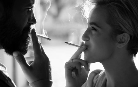 Couple find place for smoking cigarette in tranquility. Enjoying every breath of smoke. Smoking habit. Tobacco industry. Woman smoking cigarette urban background. Pause for relaxing smokingの写真素材