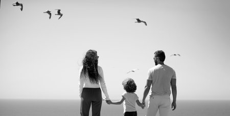 Panorama of happy beautiful family with kids walking together on sea beach during summer vacation. Freedom carefree people concept. Banner, copy cpase.の写真素材