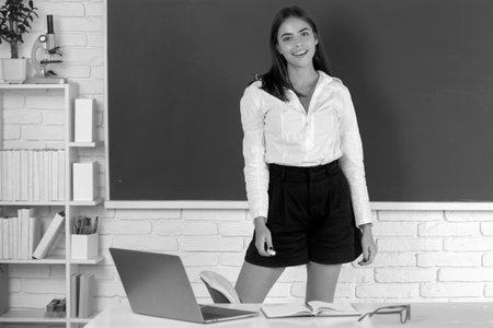 Female student stand on blackboard background in university, school education, Young woman study in college classroom.の写真素材