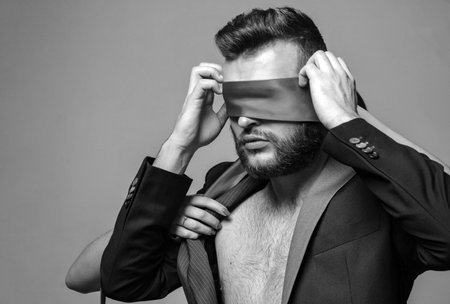 Awakening his desire. Female tease guy. Macho well groomed bearded hipster tied eyes red ribbon. Sexual relations. Sex game. Tease and seduce. Passionate lovers. Sex domination. Sex submissionの写真素材