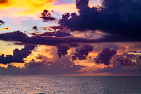 Clouds over the sea, sunrise. Sea wave. Colorful beach sunrise with calm waves. Nature sea sky. Sunrise with clouds of different colors against the blue sky and sea.の写真素材