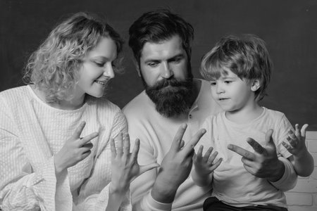 Parents encouraging their little son before the first day of school. Young happy family schooling math together. Family school partnerships examples.の写真素材