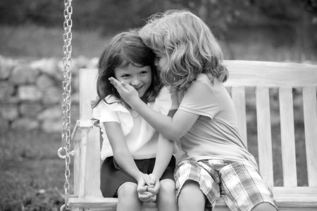Kids kissing in summer park outdoors. Little boy and girl kids enjoying summer. Best friends two children.の写真素材