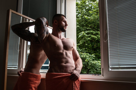 Man with naked body muscular shoulders. Naked man in bed. Muscular sexy male body. Gay sexy model. Muscular sexy man with naked torso near window curtains. Hunk with athletic body. Guy enjoying night.の写真素材