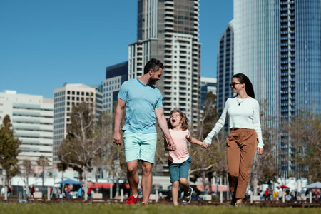Happy american family with little child son walking in modern urban city.の写真素材