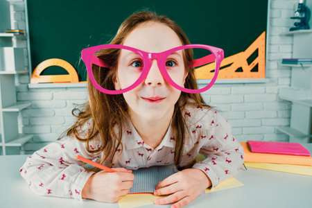 Funny pupil with glasses, home kids schooling. Child boy education concept. Cute pupil in classroom...