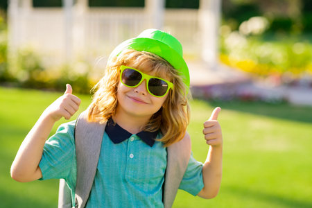 Funny kids emotions. Outdoor close up portrait of a cute little child playing outdoor. Portrait of...