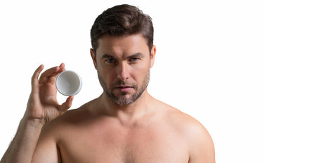 Beauty portrait of hispanic man applying face cream. Skincare cream, skin anti-aging wrinkle effect. Man applying moisturizer cream on skin. White isolated banner with copy space.の写真素材