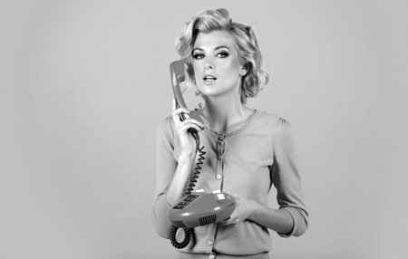 Woman talking on landline phone, retro style. isolated over pink background. Phone conversation....