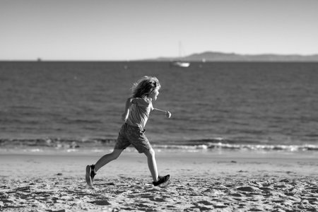 Kids running outdoors. Run and healthy sport for children. Child running on summer near sea, kids fitness.の写真素材