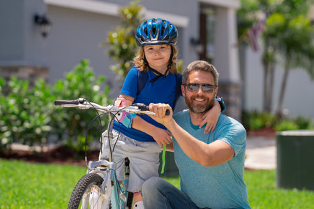 Fathers day. Father teaching son ride a bicycle. Father and son cycling on bike on summer day....