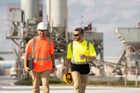 Men industrial engineer in helmet while outdoor industrial factory. Industrial machinery and...