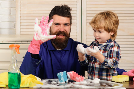 Dad and son with cleaning supplies. Father and child boy ready to do housework together. Funny housework.の写真素材