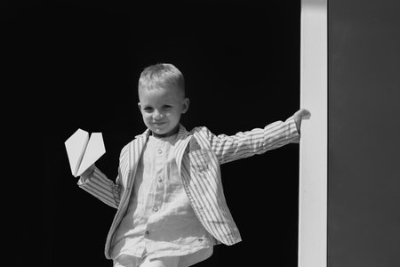 Little boy with wooden plane, boy wants to become pilot and astronaut. Happy child play with toy airplane. Kids pilot dreams of flying.の写真素材