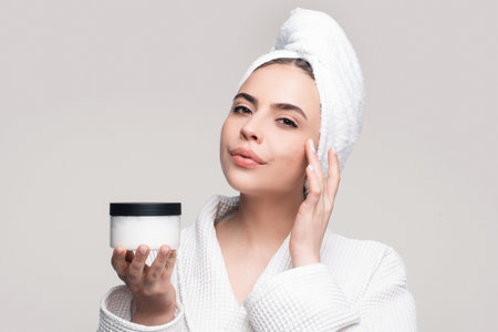 Beautiful young woman with clean fresh skin touch own face. Facial treatment. Cosmetology, beauty and spa.の写真素材