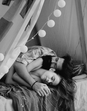 Sensual couple sleep in tent. Pair in love hugging in camping.の写真素材