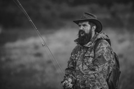 Portrait of cheerful senior man fishing. Guy fly fishing. Catching and fishing. Male hobby. Rural getaway. Mature man fly fishing. Weekend. Man catching fish. Active day. Trout bait.の写真素材
