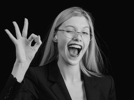 Portrait young shocked business woman winking in front of laptop computer looking at camera. Funny face expression emotion feelings problem perception reaction. Funny business. Fun female secretary.の写真素材