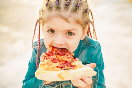 Kid eat pizza. Child eating pizza. Fastfood for kids. Italian junkfood. Children favorite food.