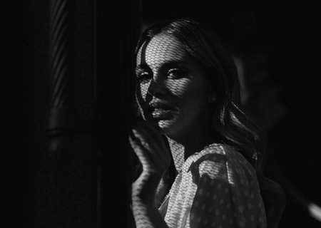 Woman face in shadow. Portrait of a young woman, close up face of beautiful woman outdoor. Cheerful female model.の写真素材