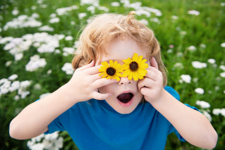 Funny child having fun outdoors. Kid playing in summer park. Little boy on green fresh grass.の写真素材