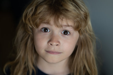 Portrait of funny blonde kid. Close-up face of cute child. Portrait of kid boy at home. Close up...
