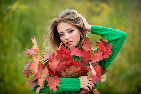 Autumn fall. Portrait young woman with autumn leafs on foliage. Beautiful girl outdoor in autumn....