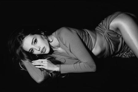 Romantic woman. Young sexy and beautiful woman in fashion dress in black bed. Sensual lady posing...