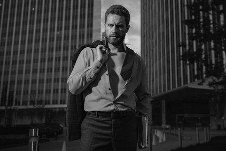 Portrait of a confident mature businessman standing outside office.