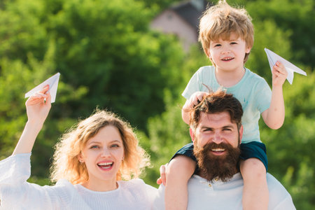 Mother father and son. Garden party in America. Happy family smiling and hugging. Cute little boy is...