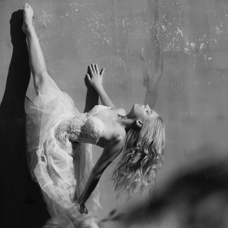 Leg-split, flexible girl doing split. Young female woman workout, fitness training at the park. Girl stretching fit body.の写真素材