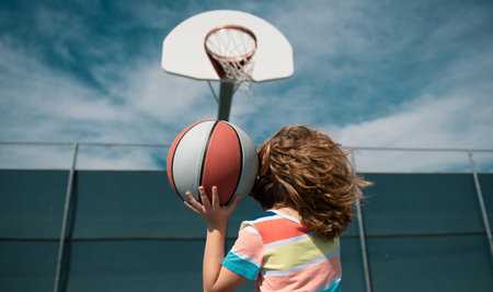 Cute little boy holding a basket ball trying make a score.の写真素材