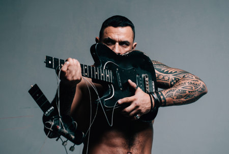 Excited sexy man with electric guitar. Music, performance, entertainment.の写真素材