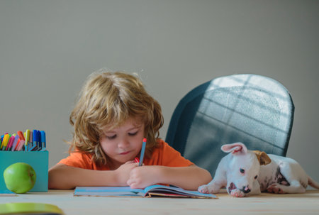 Child and pet dog playing at home. Kid pupil with puppy doing school homework.の写真素材