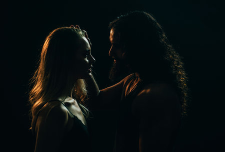 Portrait of lovely couple in love. Young sensual girlfriend glad to passionate kiss from her boyfriend. Handsome young man embraces his woman and kisses.の写真素材