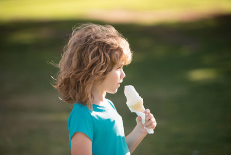 Cute child boy eating ice cream. Close up caucasian kids face. Closeup head of funny kid.の写真素材