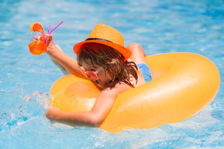 Child having fun in summertime. Summer holidays and vacation with kids. Child floating in pool....