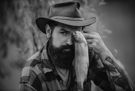 Fisher man and trout. Fisherman man on river or lake with fishing rod.の写真素材