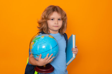 Smart child, clever school kid. School boy world globe and book. School kid 7-8 years old with book go back to school. Little student. Education concept.の写真素材