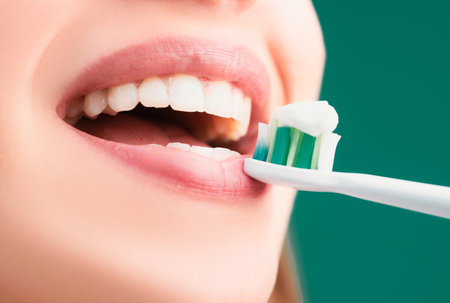 Beautiful young woman with healthy teeth, beautiful female smile. Close-up mouth with teeth-brush. Toothbrush with toothpaste.の写真素材