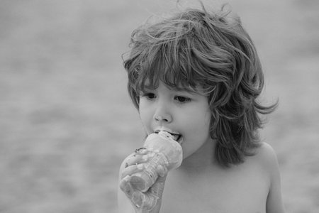 Child eating icecream. Kid with dirty face eating ice cream.の写真素材
