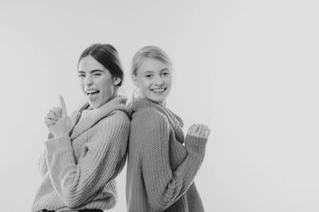 Add some action to your life. happy girls in knitted wear. sweater weather. warm clothes. knit. cashmere. friendship & family. happy to be together. handmade and diy. knitwear collection. copy spaceの写真素材