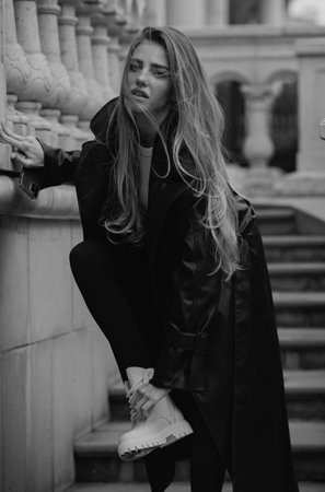 Outdoor portrait of young elegant woman walking in street. Young fashion model, urban style. Attractive woman in vogue outfit outside.の写真素材