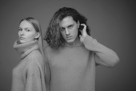 Couple on beige background in studio. Couple of man with curly hair and blonde woman in hairdresser salon. Fashionable young people.の写真素材