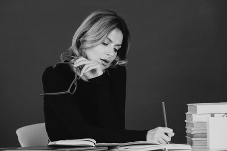 Pretty young high school or college teacher on the chalkboard. Young caucasian female business woman...