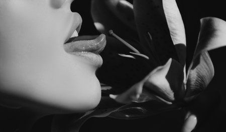 Sexy woman lick flower. Woman lips with day lily, Oriental Hybrids, lilium. Oral lesbian sex concept.の写真素材