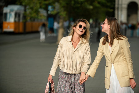 Laughing Girls with expressing positive emotions walking on the city street. Travelling in europe, budapest city. Funny vacation, romantic travel.の写真素材